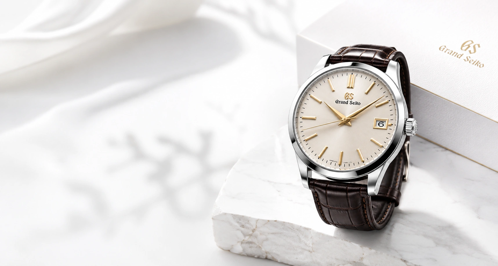 A finely finished wristwatch on a warm stone surface
